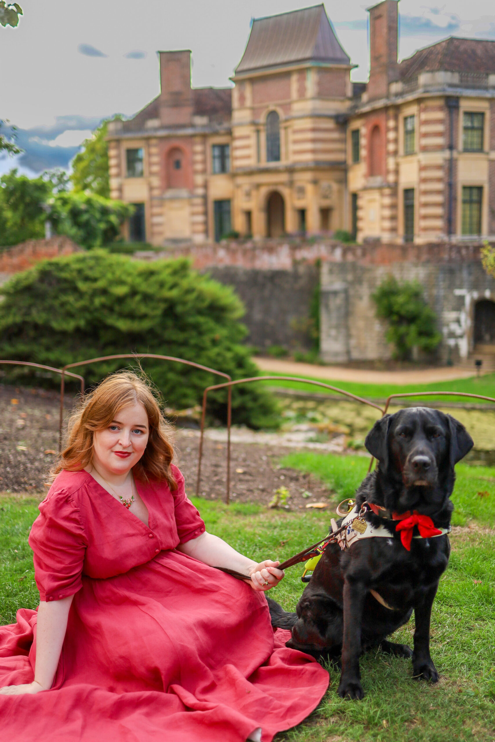 Emily wearing a pink dress with guide dog Rosie